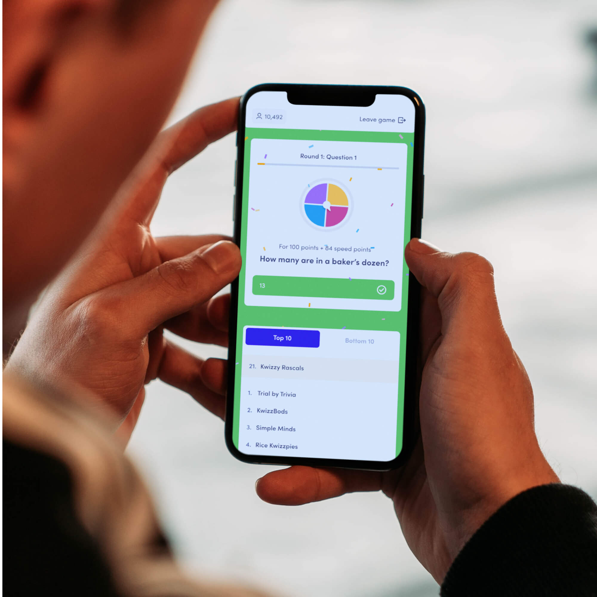 man with smartphone connected to KwizzBit virtual quiz app